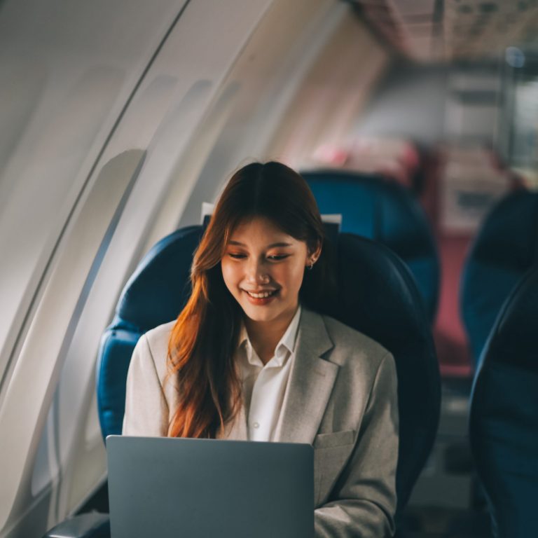 joyful-asian-woman-sits-airplane-using-tablet-while-go-travel